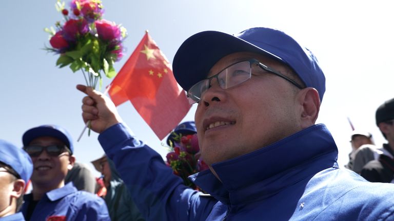A man waves flowers