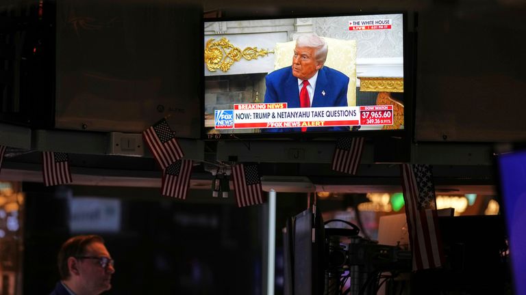 Donald Trump is seen on the television as traders work on the floor at the New York Stock Exchange. Pic: AP