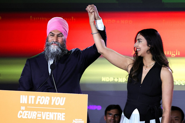 Jagmeet Singh holds up the hand of his wife