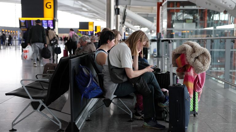 People wait at Terminal 5 of the Heathrow International Airport, a day after a fire at a nearby electrical substation wiped out the power at the airport, near London, Britain, March 22, 2025. REUTERS/Isabel Infantes

