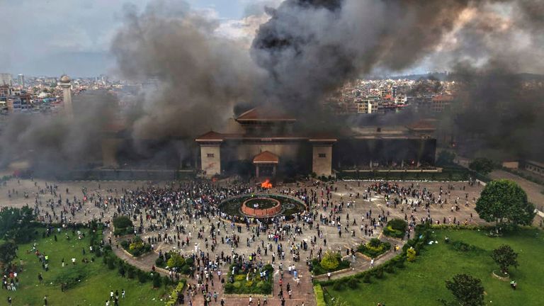 Protesters celebrate at the parliament building after it was set on fire during a protest  in Kathmandu, Nepal. Pic: AP