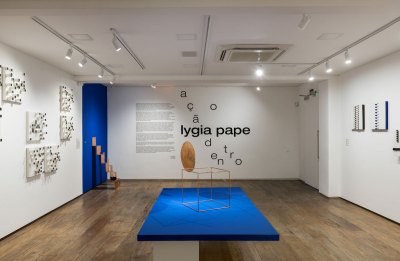 View of a sculpture exhibition in a gallery with the title and wall text on the back wall.