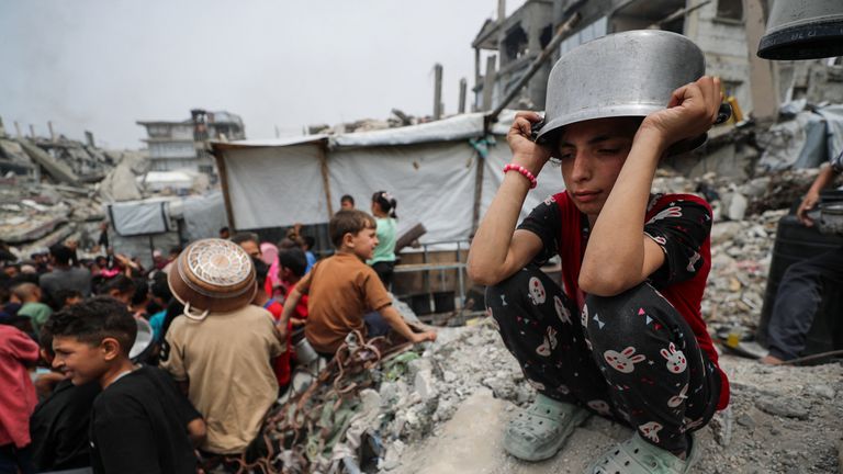 A girl puts a pot over her head in Beit Lahia, northern Gaza. Pic: Reuters