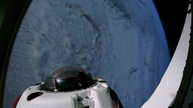 This photo provided by SpaceX shows the domed window of the Dragon capsule with a polar region of the Earth in the background on Tuesday, April 1, 2025. (SpaceX via AP)