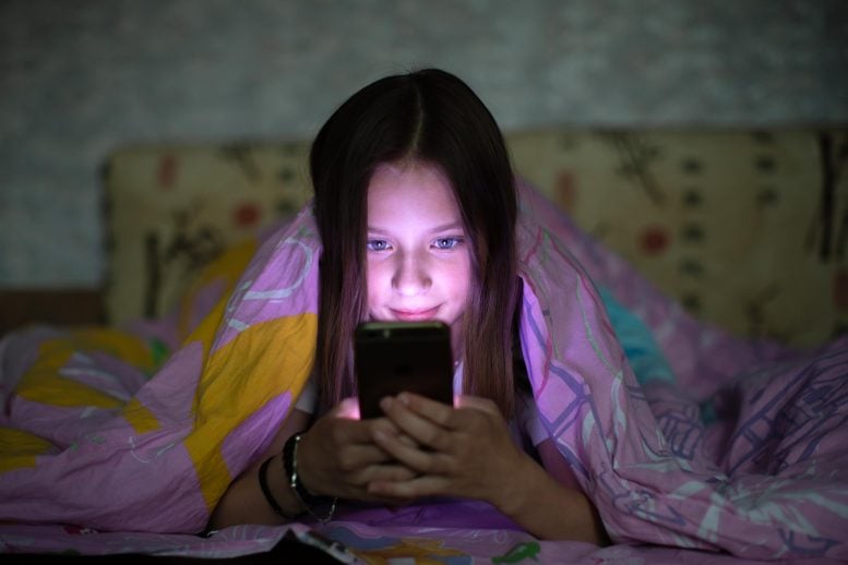 Teenage Girl Under Blanket Browsing Phone