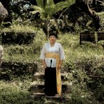 Portrait of Citra Sasmita standing outside in a lush area.