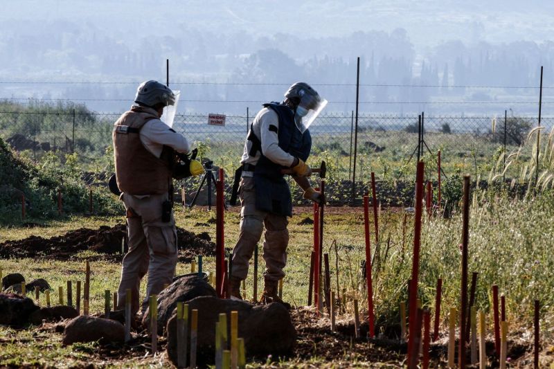 Lebanese deminers with the Mines Advisory Group, a nongovernmental organization, work in a field in southern Lebanon, near the border with Israel, on April 13, 2021.