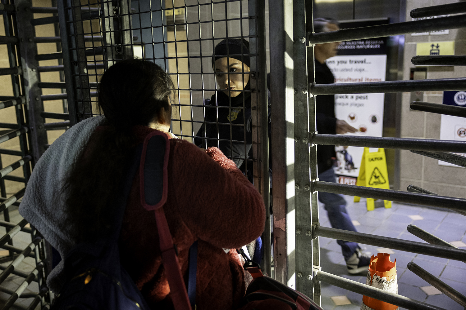 An immigrant speaks to a security officer at the United States border.