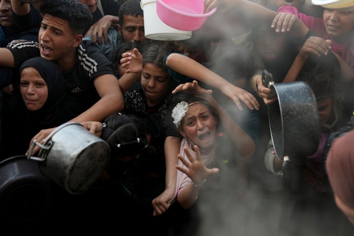 A Palestinian girl cries out as she and others desperately try to receive food at an aid distribution center in northern Gaza's Beit Lahiya, on March 16, 2025.