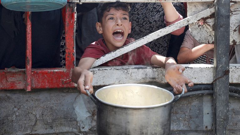 A Palestinian reacts as he waits to receive food from a charity kitchen in Gaza.
Pic Reuters