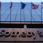 A skyscraper with flags and a sign reading Sotheby's.