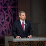 A man in a suit at a podium.