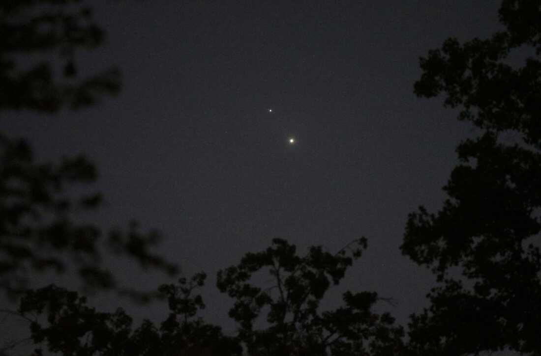 In a darkened night sky, the planets Venus, bottom, and Jupiter are seen as bright orbs above Matthews, N.C., in 2015. 