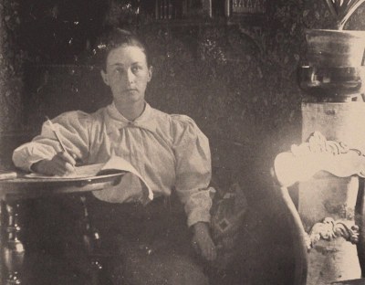 A woman writing on a piece of paper.