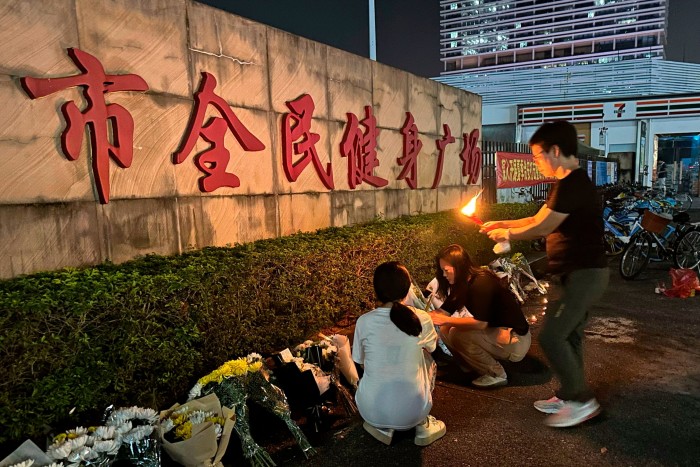 People lay flowers near the site in Zhuhai city where a man rammed his vehicle into a crowd, killing 35 people