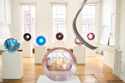 A group of semi-transparent discs on pedestals in a gallery.
