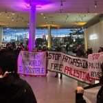 A group of protestors in a museum lobby.