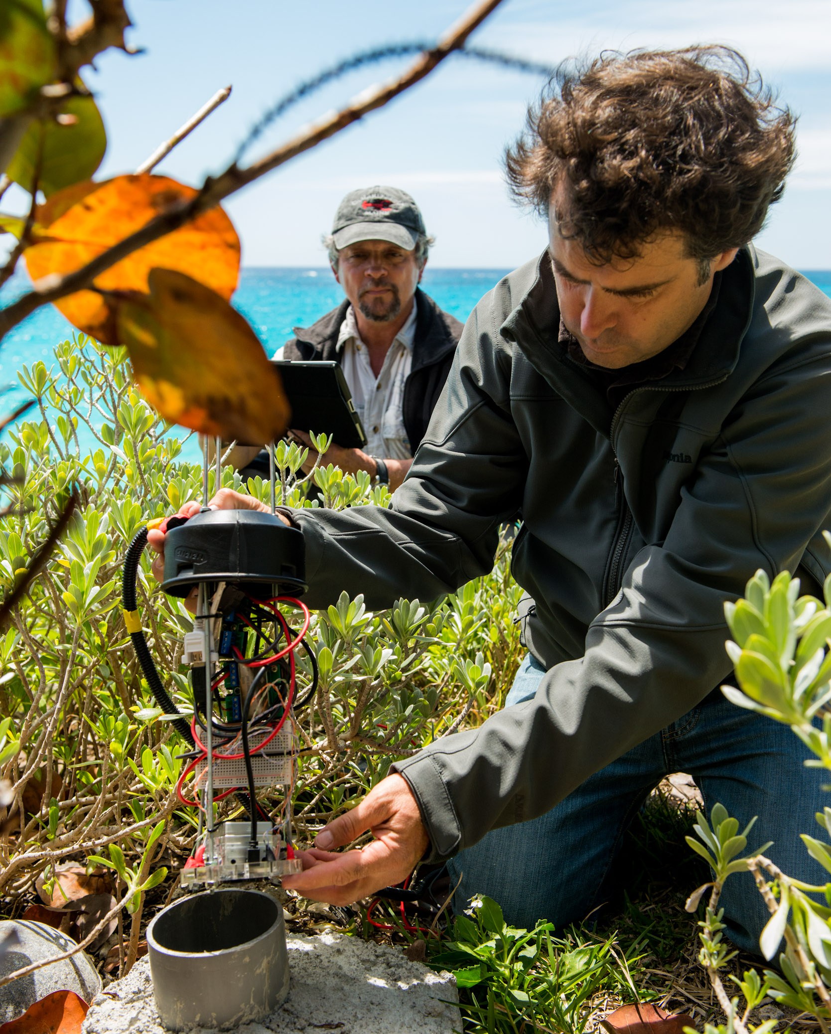 Jean-Pierre Rouja installing prototype CahowCam in 2013 while Nonsuch Island warden Jeremy Madeieros looks on.