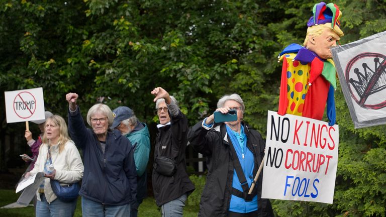 Demonstrators protest near Trump National Golf Club before the arrival of the president. 
Pic: AP/Rod Lamkey Jr