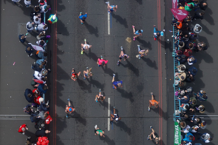 Aerial view of competitors running across Tower Bridge in a London Marathon